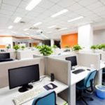 open office full of white cubicles and workstations